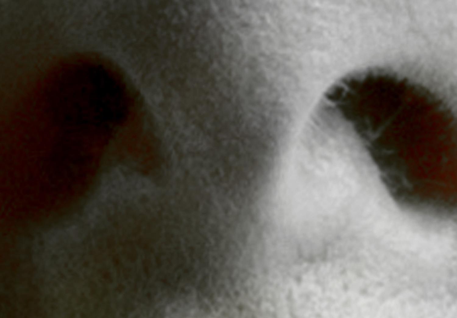 Cuadro decorativo Labios cálidos - primer plano del rostro de una mujer en tonos de gris