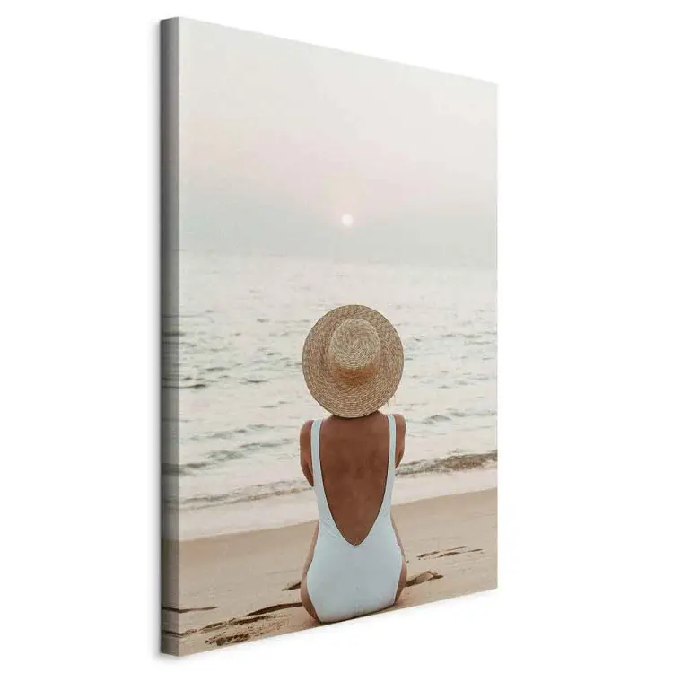 Mujer con sombrero en la playa - paisaje marino con la puesta de sol