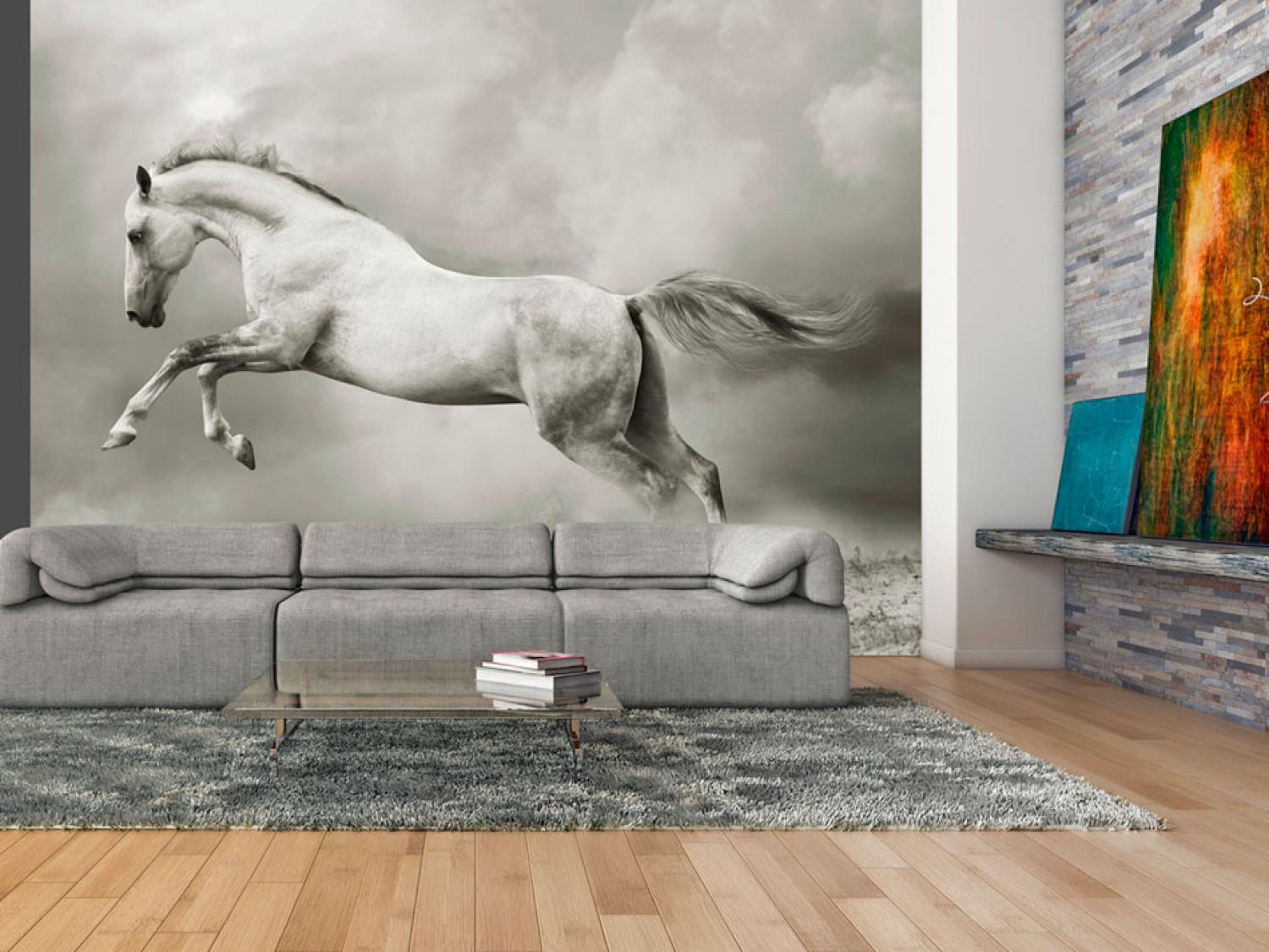 Fotomural a medida Potro fuerte - caballo blanco saltando en arena entre humo gris